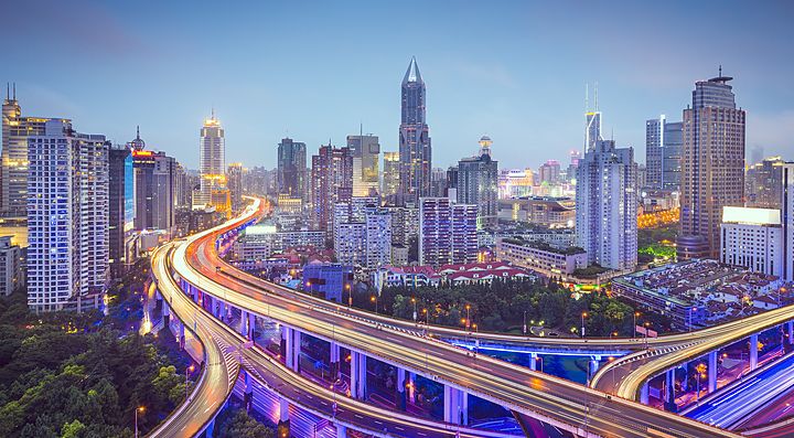 Panorama urbano di Shanghai con grattacieli e strade illuminate.