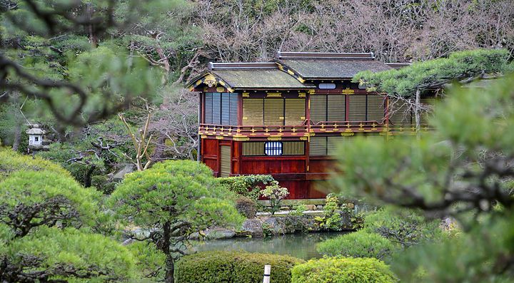 Giardino Sorakuen con struttura tradizionale tra alberi e cespugli verdi.