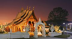 Tempio illuminato al tramonto in Laos con cielo arancione.