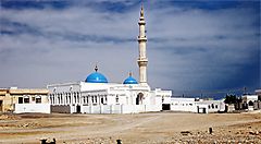 Una moschea con cupole blu nel paesaggio desertico dell'Oman.