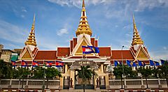 Edificio con tetti dorati in Cambogia decorato con bandiere.
