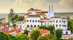 Palazzo storico a Sintra, Portogallo, circondato da alberi e edifici.