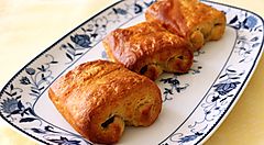 Tre viennoiserie su un piatto decorato in stile austriaco.