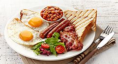 Colazione inglese con uova, bacon, salsicce, fagioli e pane tostato.