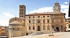 La Piazza Grande di Arezzo con edifici storici e una torre.