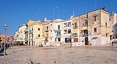 Piazza con edifici storici a Bari sotto un cielo blu terso.