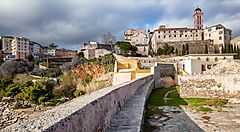Vista panoramica di Bastia con antiche mura e palazzi storici.