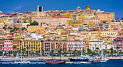 Panorama del centro storico di Cagliari con palazzi colorati e porto.
