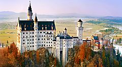 Il castello di Neuschwanstein in Germania tra colline e foreste.