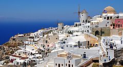 Vista di un villaggio con case bianche e mulino a vento in Grecia.