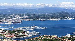 Vista panoramica del porto della Spezia con montagne sullo sfondo.