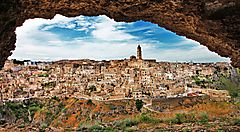 Veduta panoramica di Matera con le sue antiche costruzioni sotto un cielo nuvoloso.