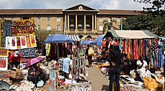 Mercato vivace all'aperto a Nairobi con bancarelle colorate e persone.