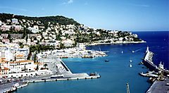 Porto di Nizza con edifici e colline sullo sfondo.