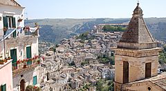 Veduta panoramica di Ragusa con edifici storici e paesaggio collinare.