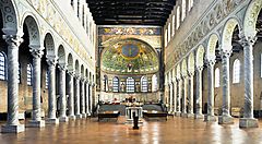 Interno di una basilica a Ravenna con colonne e mosaici brillanti.