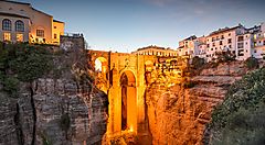 Il Ponte Nuevo di Ronda al tramonto sopra un profondo canyon.