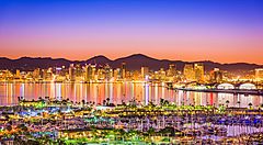 Skyline di San Diego al tramonto con riflessi sul mare e porto turistico.