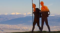 Due sculture di pellegrini sullo sfondo delle montagne a Santiago.
