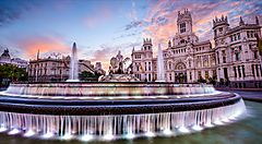 Fontana di Cibeles a Madrid al tramonto con cielo rosa.