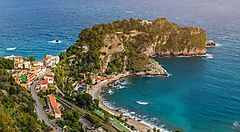 Vista panoramica della costa e della baia di Taormina con mare azzurro.