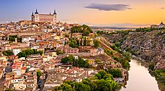 Panorama di Toledo al tramonto con fiume e città storica.