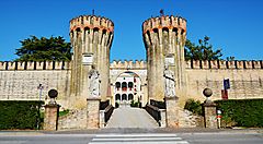 Ingresso con torri medievali a Treviso sotto un cielo azzurro.