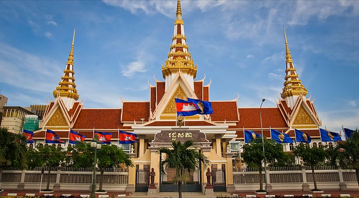Edificio con tetti dorati in Cambogia decorato con bandiere.
