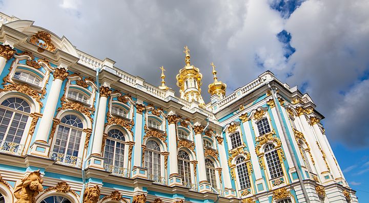 Palazzo con dettagli dorati a San Pietroburgo sotto cielo nuvoloso.