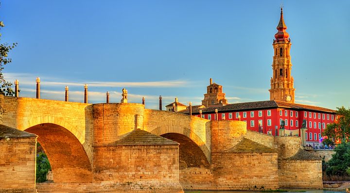 Ponte di pietra e torre storica al tramonto in Spagna.