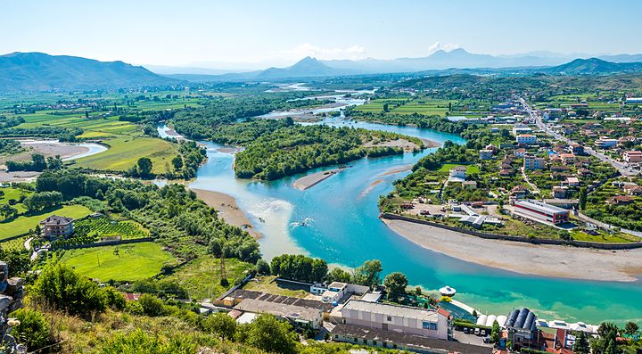 Panorama di un fiume che attraversa un paesaggio verdeggiante in Albania.