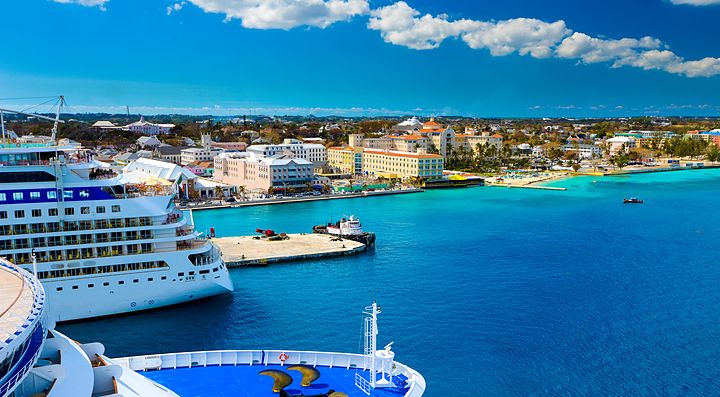Nave da crociera nel porto delle Bahamas con skyline cittadino.