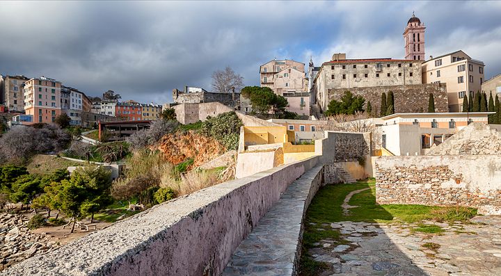 Vista panoramica di Bastia con antiche mura e palazzi storici.