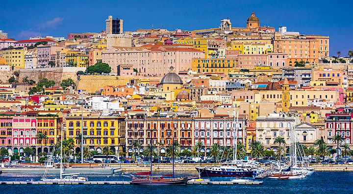 Panorama del centro storico di Cagliari con palazzi colorati e porto.
