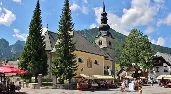 Chiesa e montagne a Kranjska Gora con cielo sereno.
