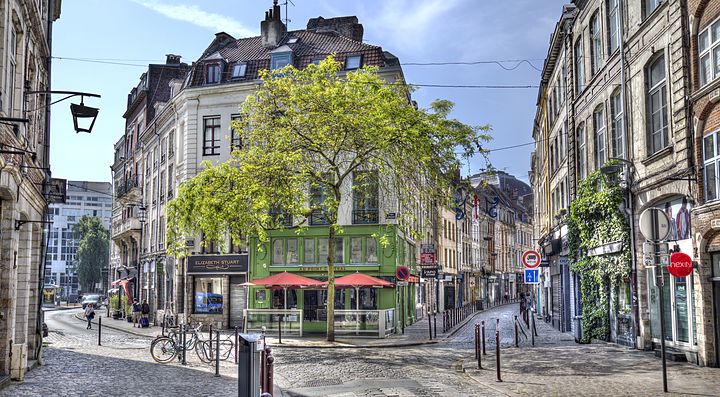 Strada acciottolata con edifici storici e caffè a Lilla.
