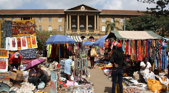 Mercato vivace all'aperto a Nairobi con bancarelle colorate e persone.
