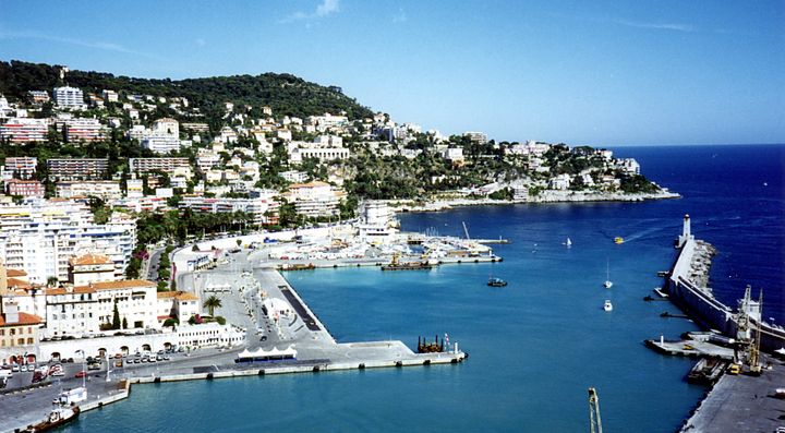 Porto di Nizza con edifici e colline sullo sfondo.