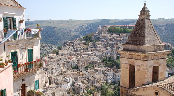 Veduta panoramica di Ragusa con edifici storici e paesaggio collinare.