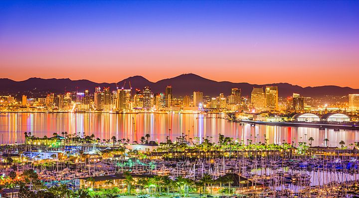 Skyline di San Diego al tramonto con riflessi sul mare e porto turistico.