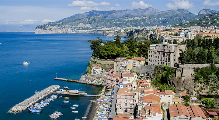 Vista panoramica di Sorrento con costa, edifici e mare azzurro.