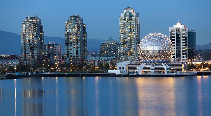 Skyline di Vancouver al tramonto con il Science World illuminato.