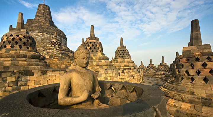 Statue e stupa nel sito di Borobudur al tramonto, Indonesia.