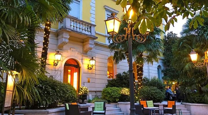 Ingresso dell'Hotel Rovereto illuminato con decorazioni serali.