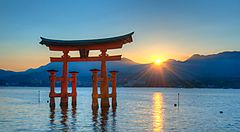 Un torii rosso nell'acqua al tramonto in Giappone.