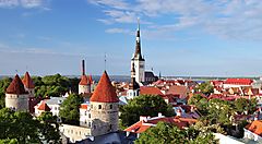 Paesaggio di Tallinn in Estonia con torri medievali e chiese sotto un cielo azzurro.