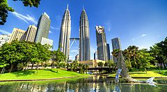 Le Petronas Towers a Kuala Lumpur, circondate da un parco verde.