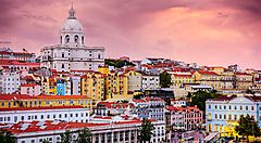 Veduta su Lisbona con edifici colorati e cielo al tramonto.
