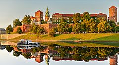 Castello di Wawel a Cracovia riflesso nel fiume con barca.