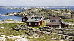 Case rosse tradizionali su una costa rocciosa in Svezia.